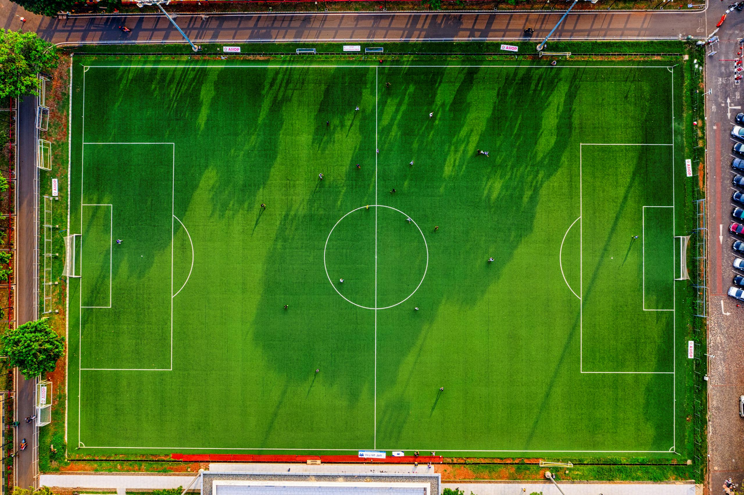Drone shot of a soccer field in Jakarta, Indonesia with players practicing.